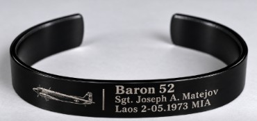 Black metal cuff bracelet engraved with an EC-47 aircraft and the words Baron 52, Sgt. Joseph A. Matejov, Laos 2-05.1973 MIA