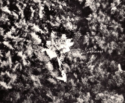 Aerial photo of the Baron 52 wreckage lying upside down in the Laotian jungle, wings sheared off